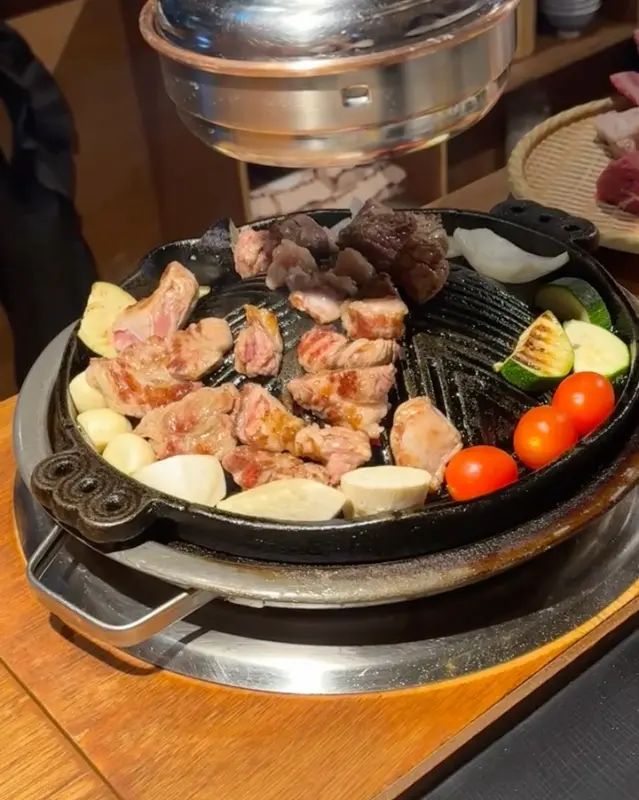 숯불 위에서 구워지고 있는 양갈비와 채소들