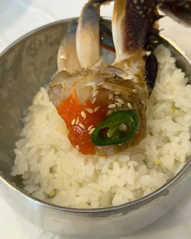 밥 위에 간장게장을 올린 모습