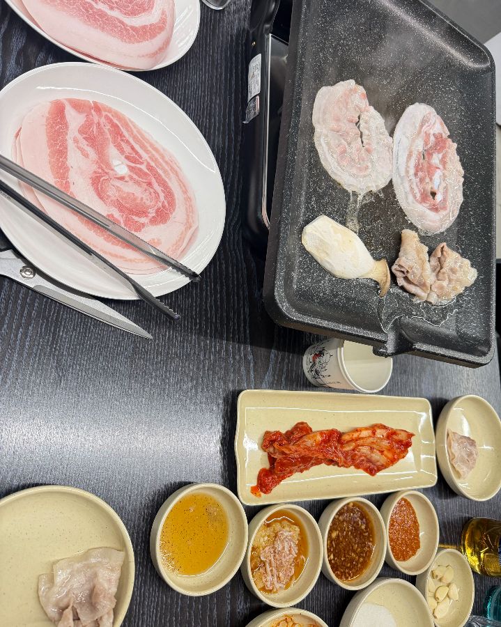 다양한 밑반찬과 소스가 푸짐하게 차려진 테이블