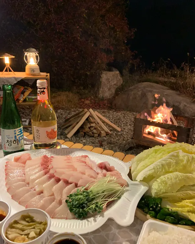 캠핑 테이블 위의 푸짐한 방어회 한 상