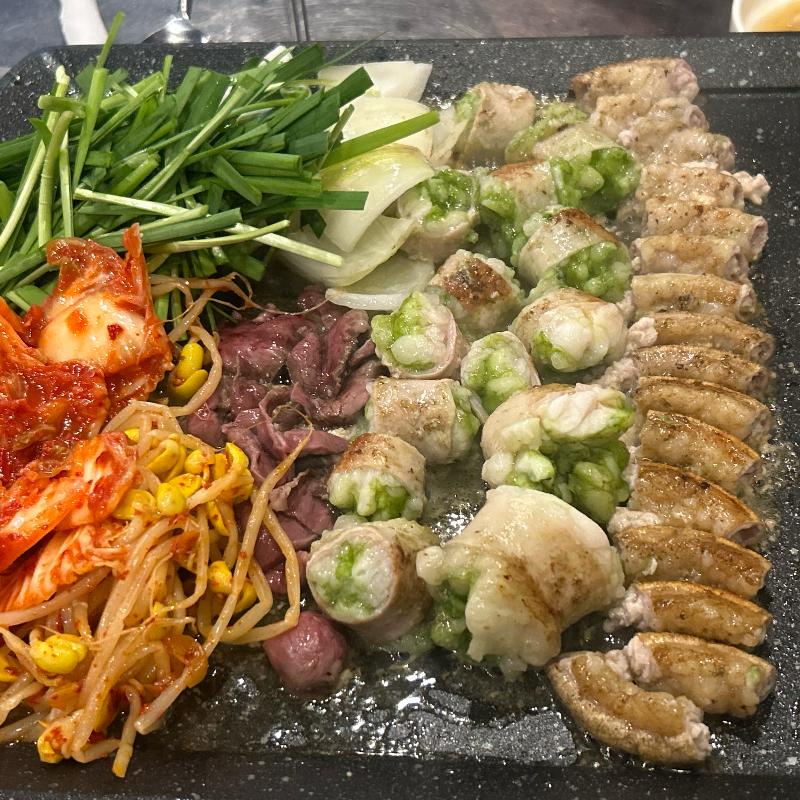 불판 위에 푸짐하게 구워진 곱창, 막창, 대창