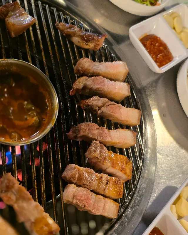 초벌된 흑돼지가 연탄불 위에 가지런히 놓여 있는 모습