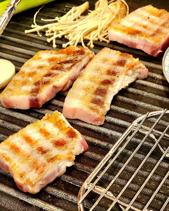 불판 위에서 구워지고 있는 삼겹살