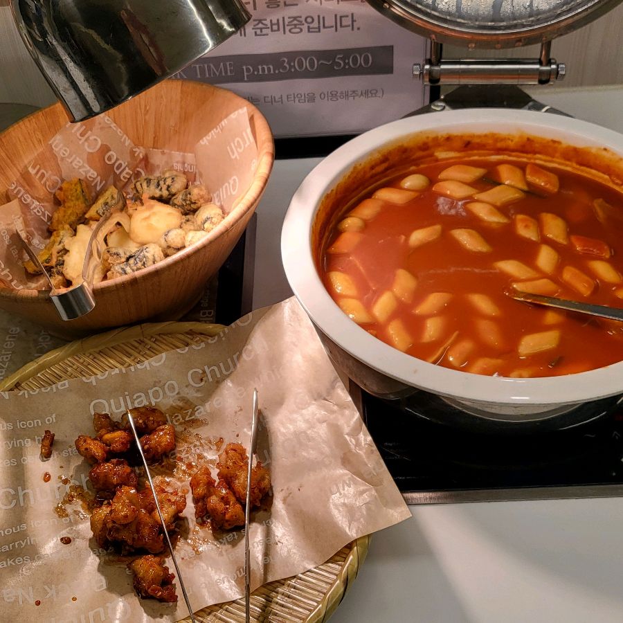샐러드바에 놓인 떡볶이와 튀김, 닭강정