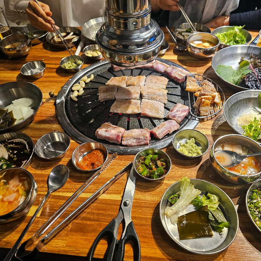 다양한 밑반찬과 숯불, 그리고 생갈비가 놓여진 풍성한 테이블 전경