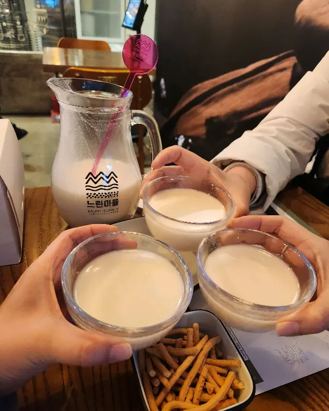 투명한 유리잔에 뽀얀 막걸리가 담겨 있는 모습