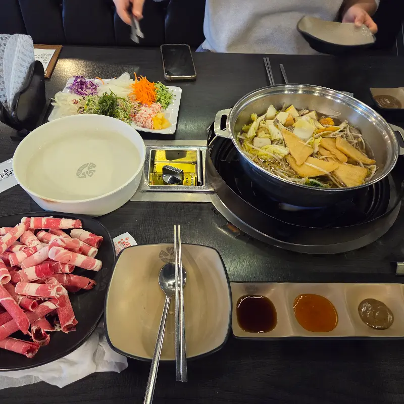 테이블 가득 차려진 샤브샤브와 월남쌈 재료