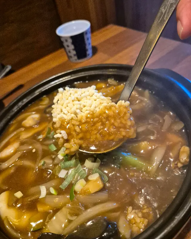 해물누룽지탕을 숟가락으로 뜨는 모습