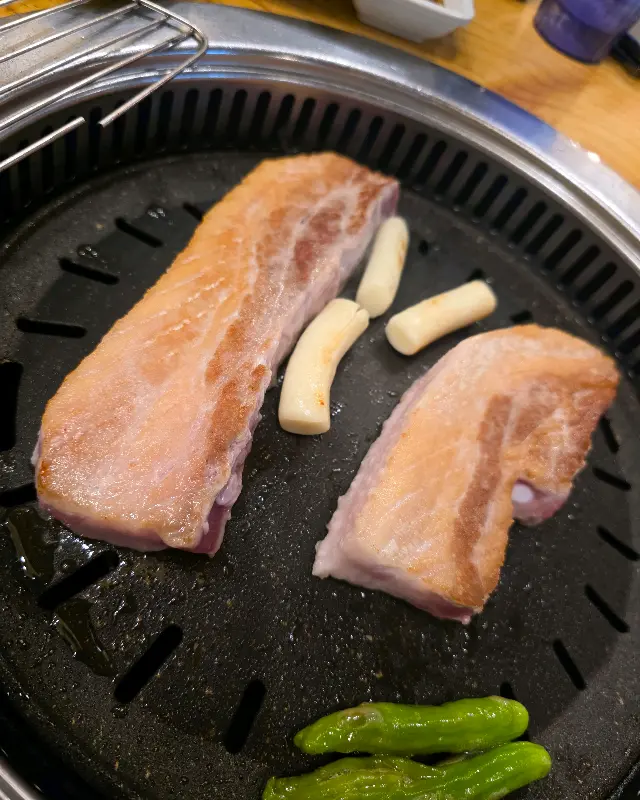 맛있게 구워진 삼겹살과 곁들임 채소