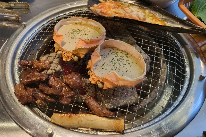 불판 위에서 익어가는 다양한 음식들