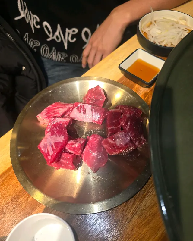 맛있게 구워진 큐브 눈꽃살을 쌈에 싸서 먹는 모습