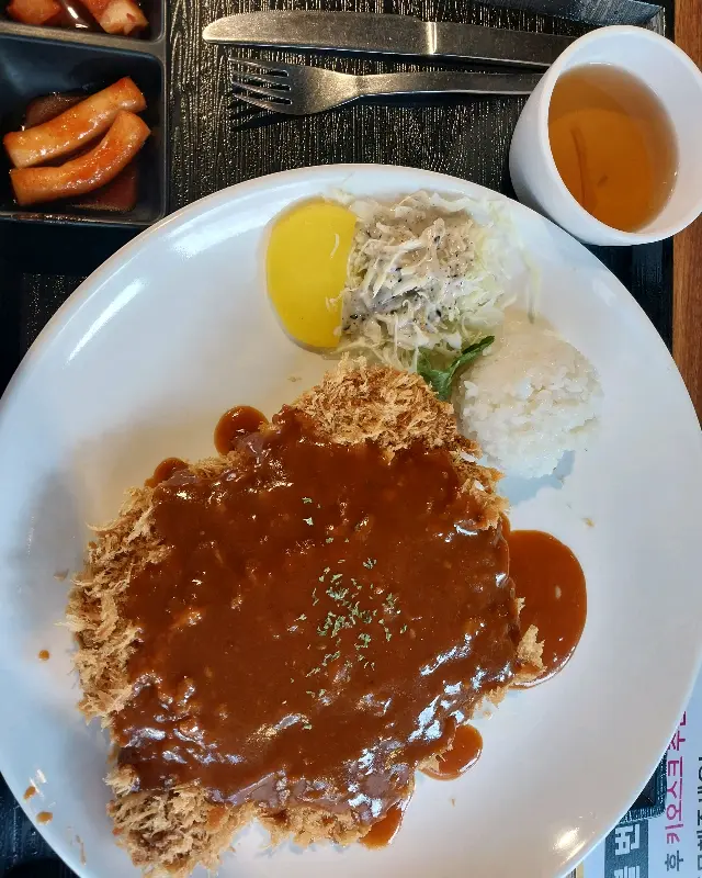 돈까스 위에 소스가 듬뿍 뿌려진 모습