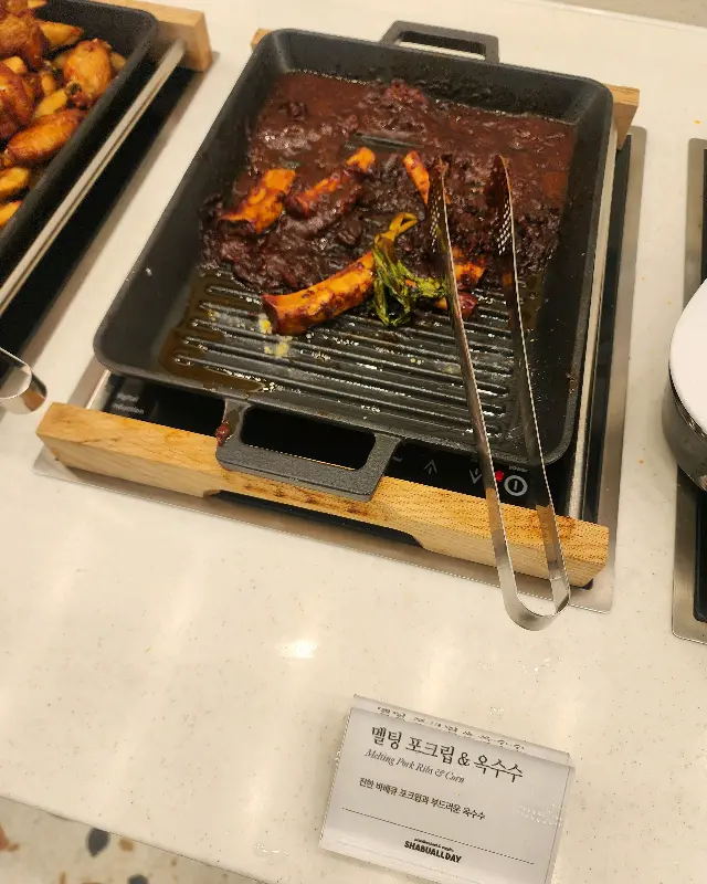 샐러드바에 놓인 멜팅 폭립과 볶음 옥수수