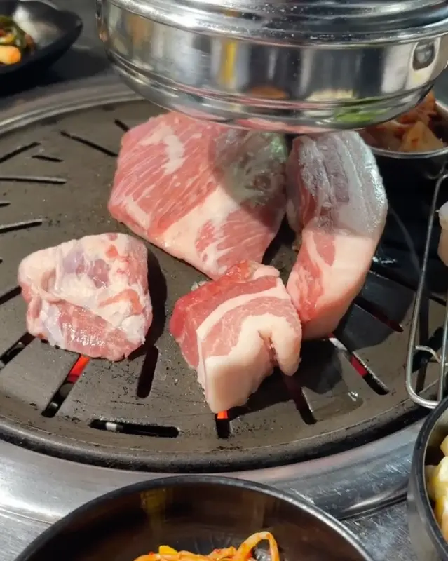 숯불 위에서 익어가는 두툼한 삼겹살