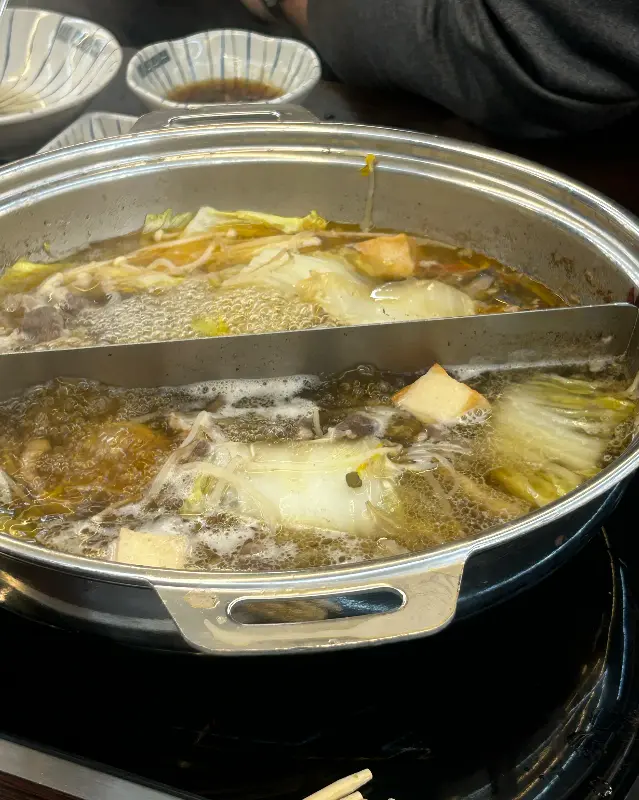 샤브샤브 냄비에 각종 야채와 고기를 넣고 끓이는 모습