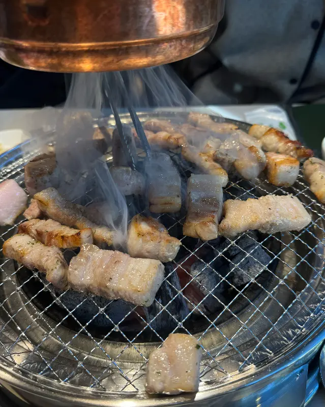 숯불 위에서 맛있게 구워지고 있는 삼겹살