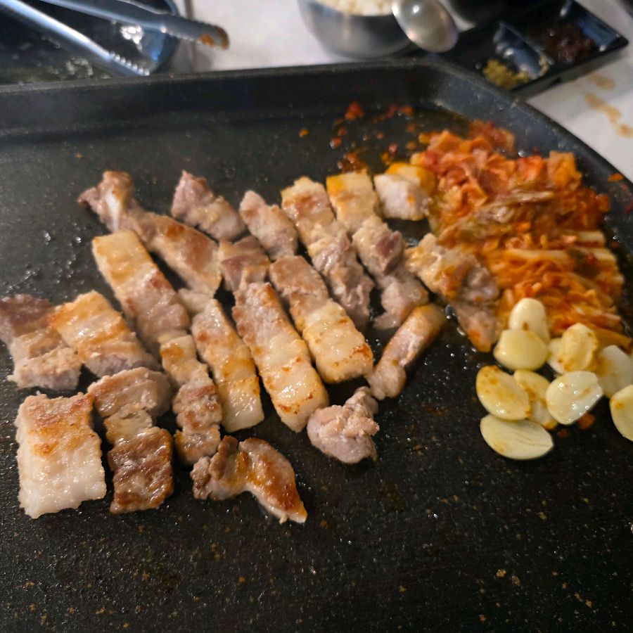 불판 위에서 구워진 삼겹살과 김치