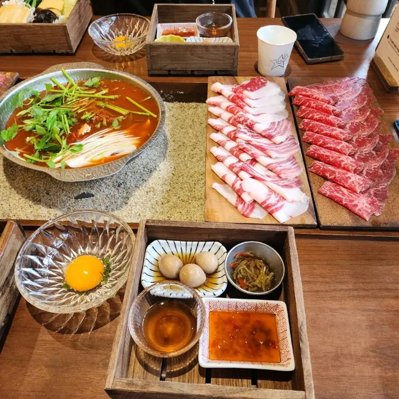 샤브샤브 재료와 소스, 계란 등이 정갈하게 담겨 나온 모습