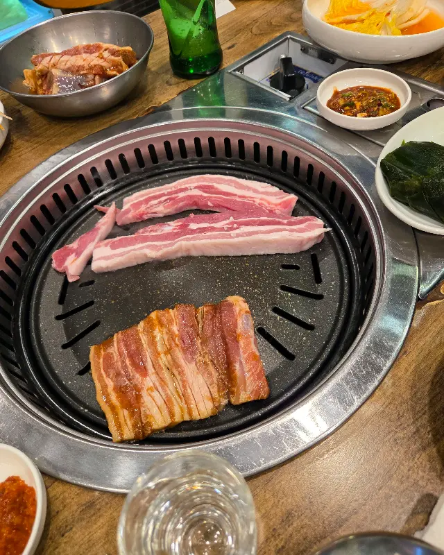 불판 위에서 익어가는 삼겹살의 모습