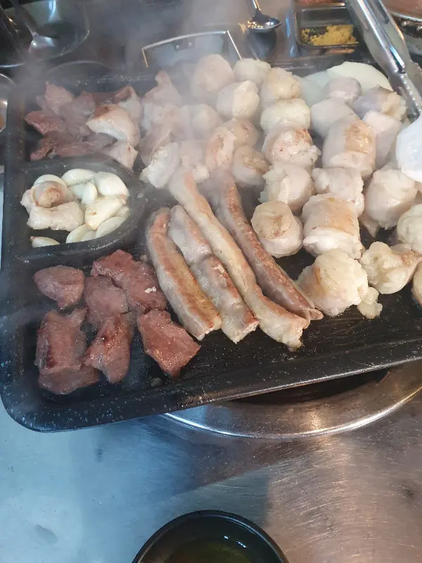 연기가 모락모락 피어오르는 뜨거운 불판 위의 곱창