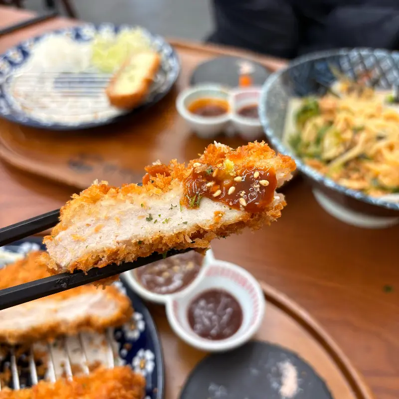 젓가락으로 들어올린 돈까스 단면