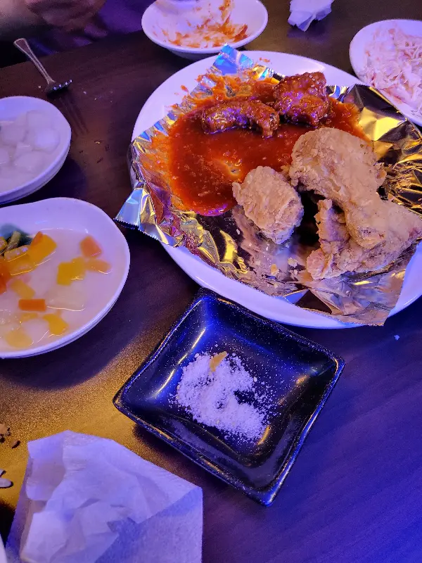 접시에 담긴 양념치킨과 후라이드 치킨, 그리고 곁들임 메뉴