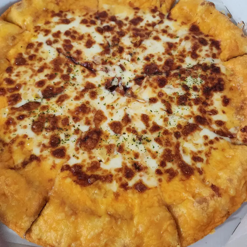 치즈 토핑이 듬뿍 올려진 피자의 모습