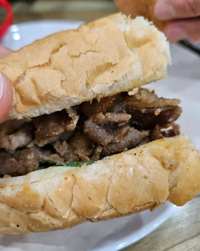 반미 샌드위치의 단면 사진. 빵 속에 고기와 야채가 가득 차 있다.