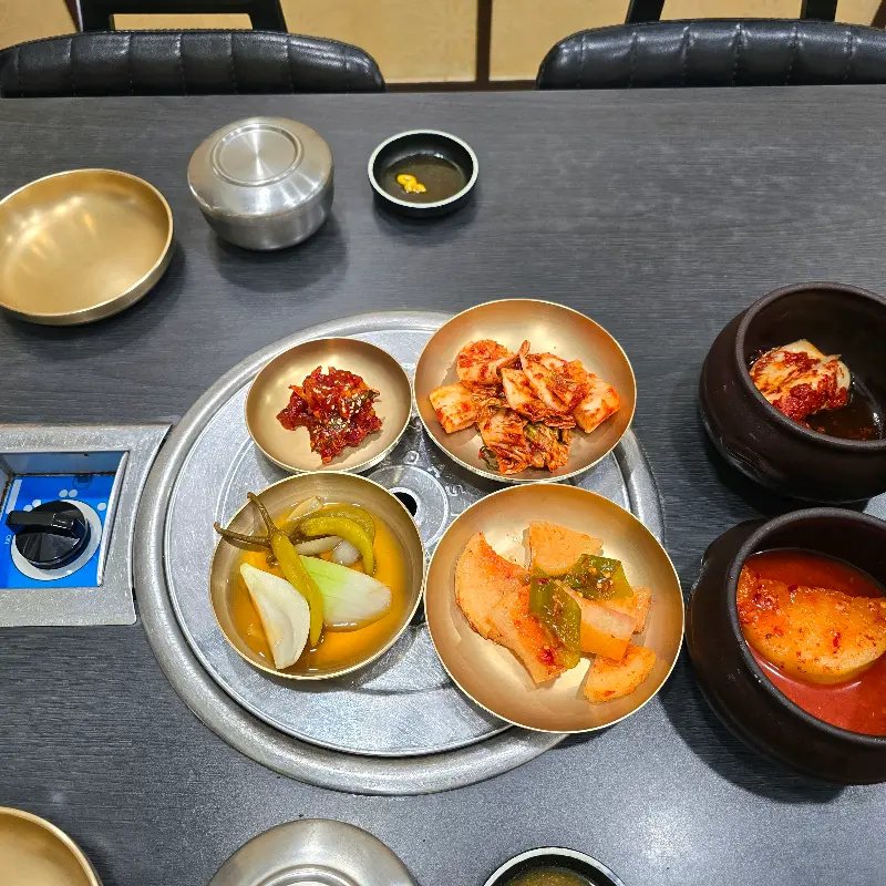 테이블 위 놋그릇에 담긴 밑반찬들