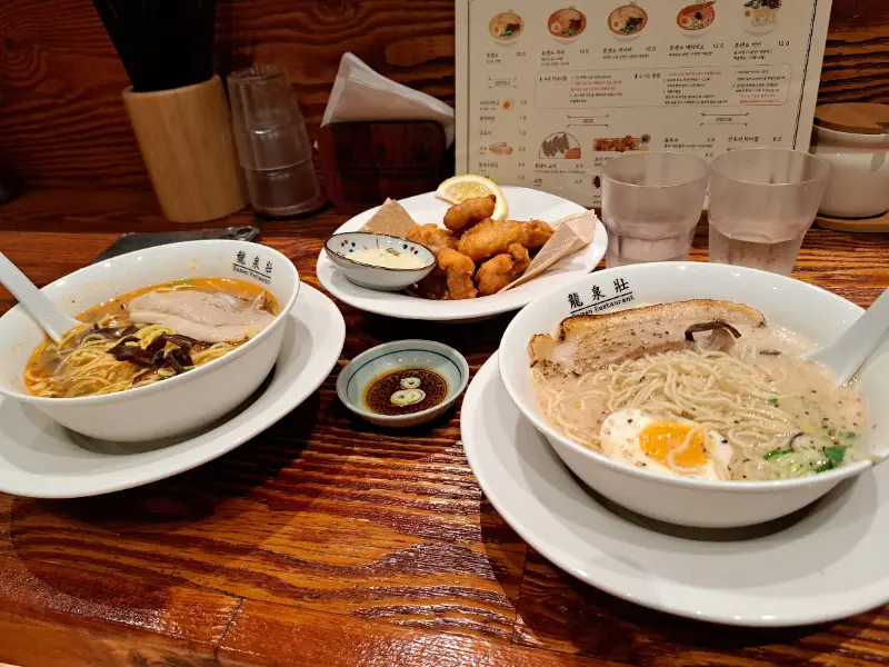 테이블 위에 놓인 두 그릇의 라멘과 토리 가라아게