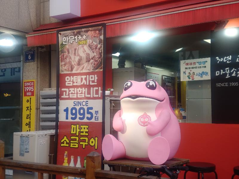 맛있게 구워진 고기와 비빔국수를 함께 곁들여 먹는 모습