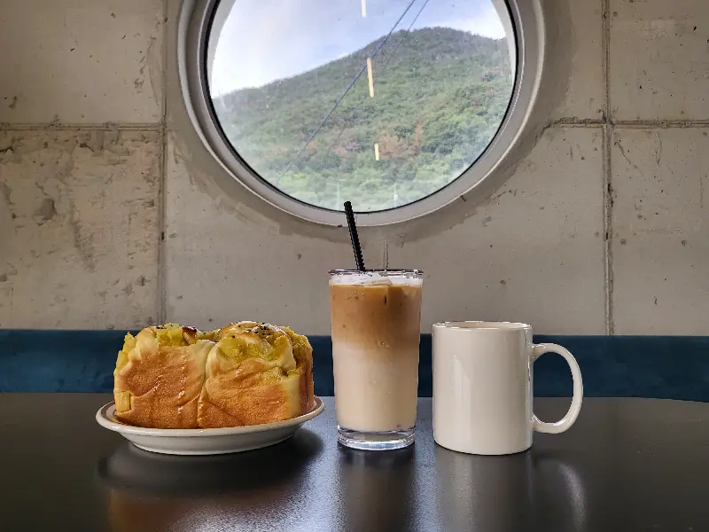 창밖 풍경을 바라보며 커피와 빵을 즐기는 여유