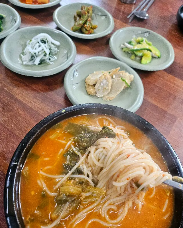 젓가락으로 면을 들어올린 모습. 김가루와 쑥갓이 보인다.