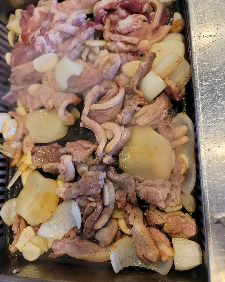 오리고기와 양파, 마늘을 함께 구워 먹는 모습