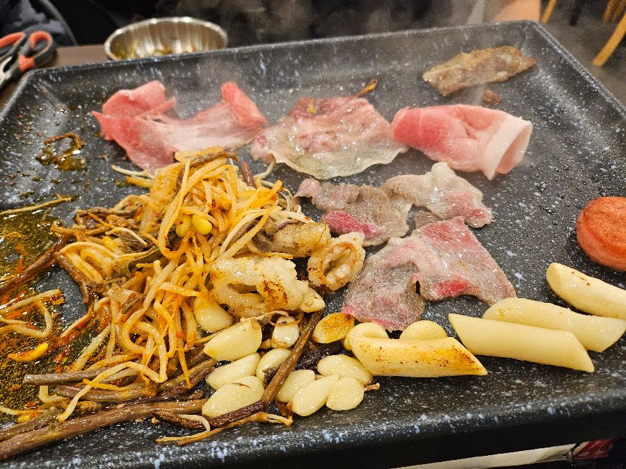 불판 위에서 맛있게 익어가는 꽃삼겹살과 곁들임