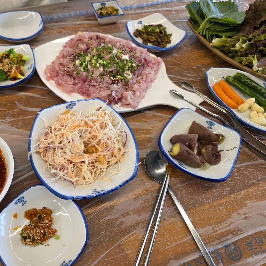 향어회와 다양한 밑반찬이 차려진 테이블