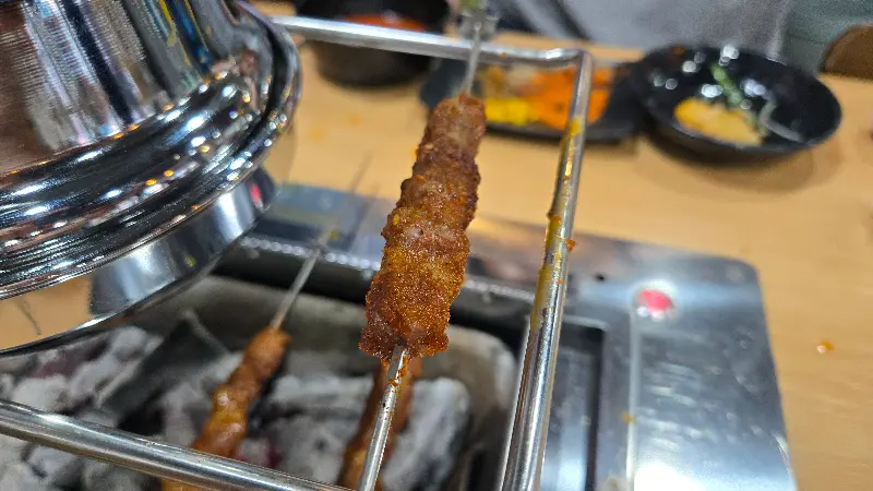 노릇하게 구워진 양꼬치 한 점