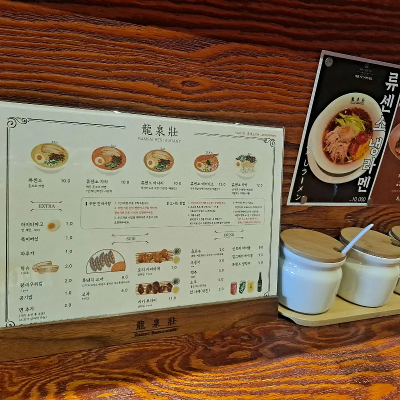 테이블 위에 놓인 메뉴판과 조미료 통