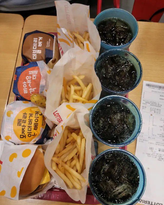 쟁반 위에 놓인 햄버거, 감자튀김, 음료