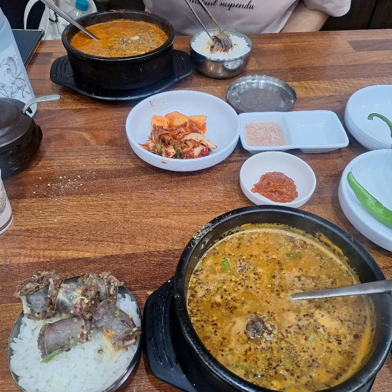테이블 위에 순대국, 순대, 김치, 깍두기 등이 푸짐하게 차려져 있다.