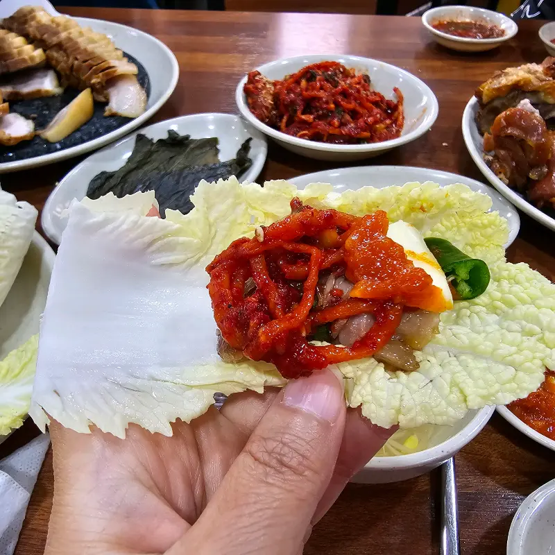 배추쌈에 족발과 김치를 올려 한 입