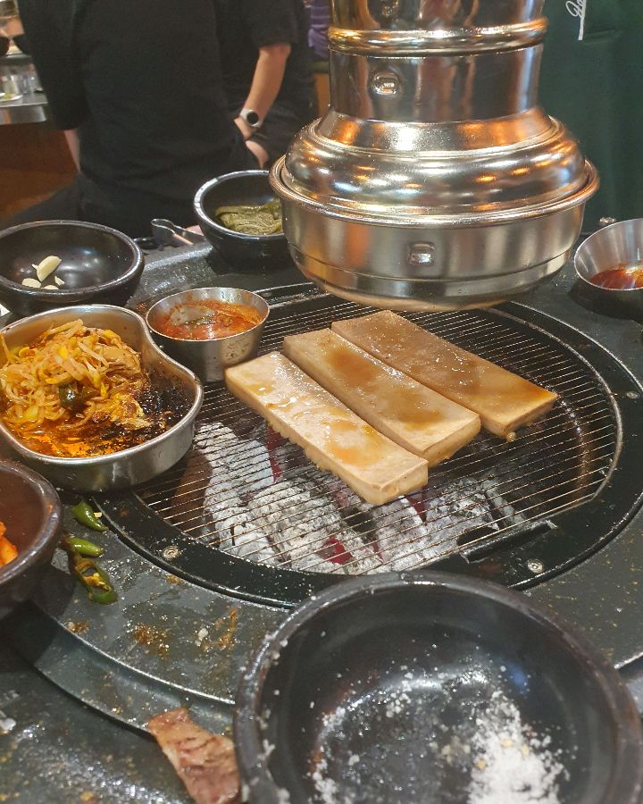 불판 위에 가지런히 놓인 숙성 삼겹살