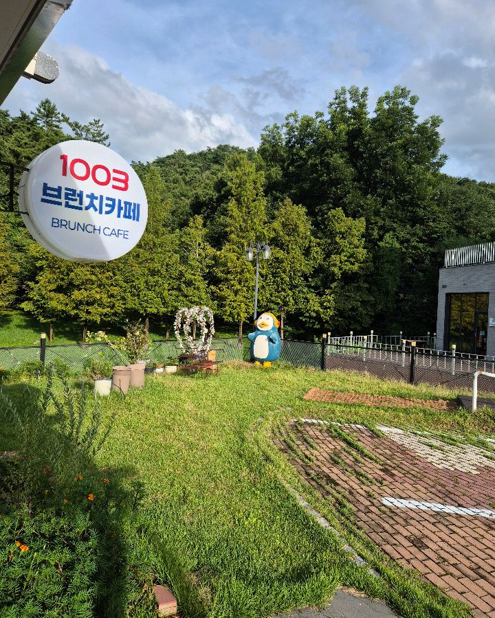 푸른 잔디밭과 나무들이 어우러진 카페 외부 전경