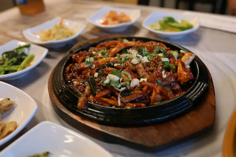 매콤달콤한 양념에 버무려진 오징어볶음이 푸짐하게 담겨 있는 사진