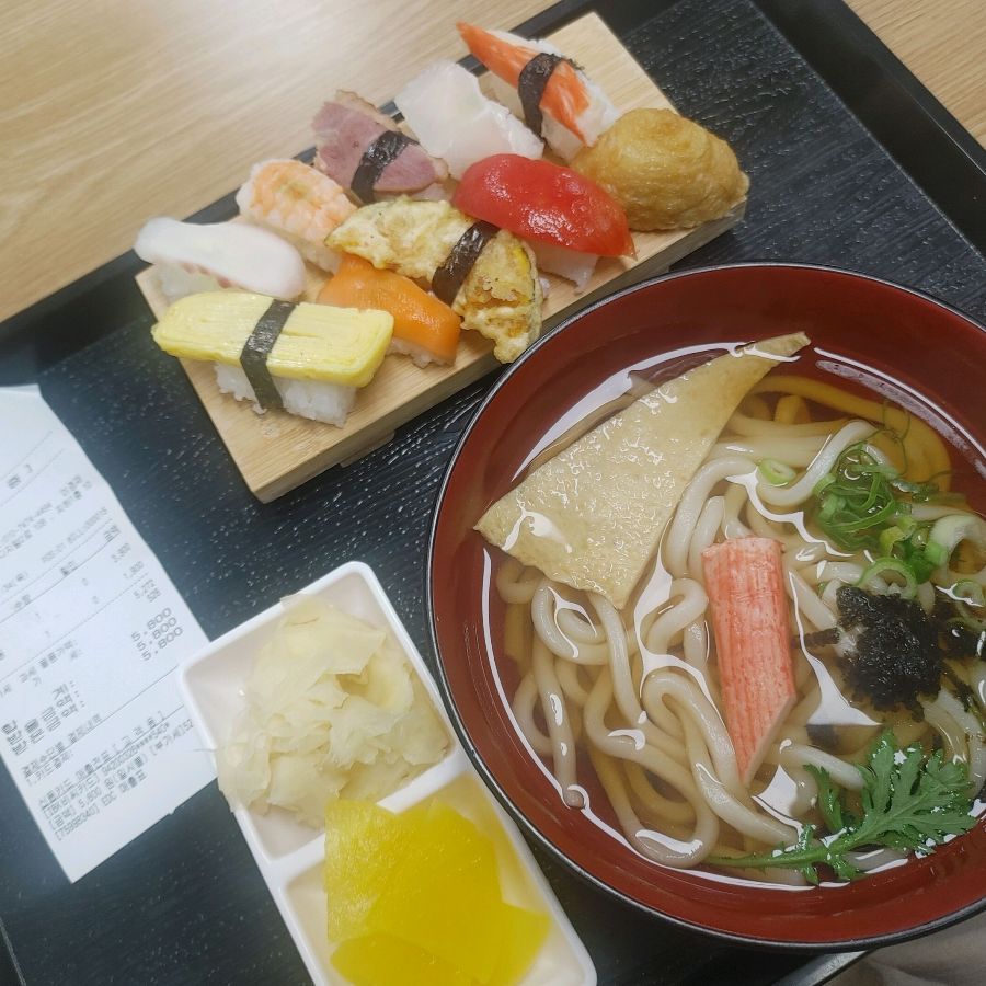 모듬 초밥과 우동이 함께 담긴 쟁반