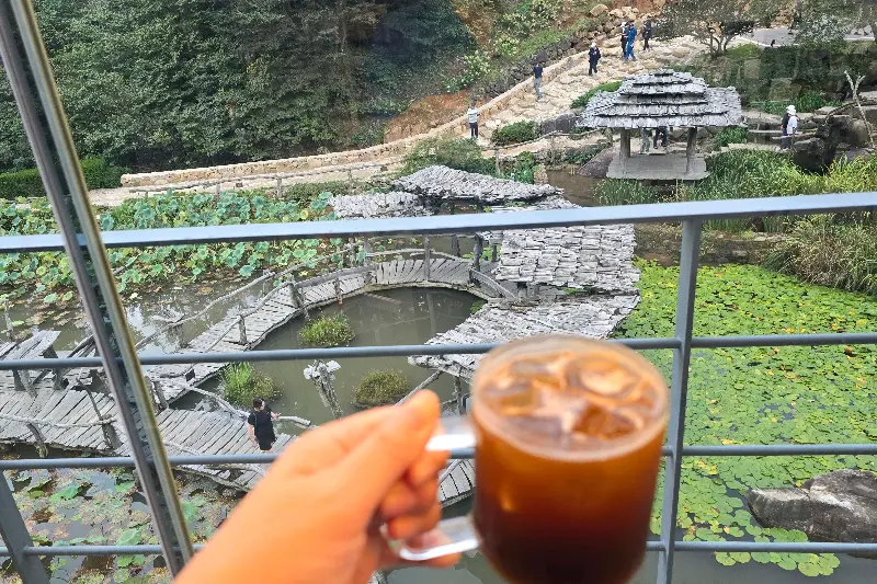 아이스 아메리카노를 들고 창밖 풍경을 감상하는 모습