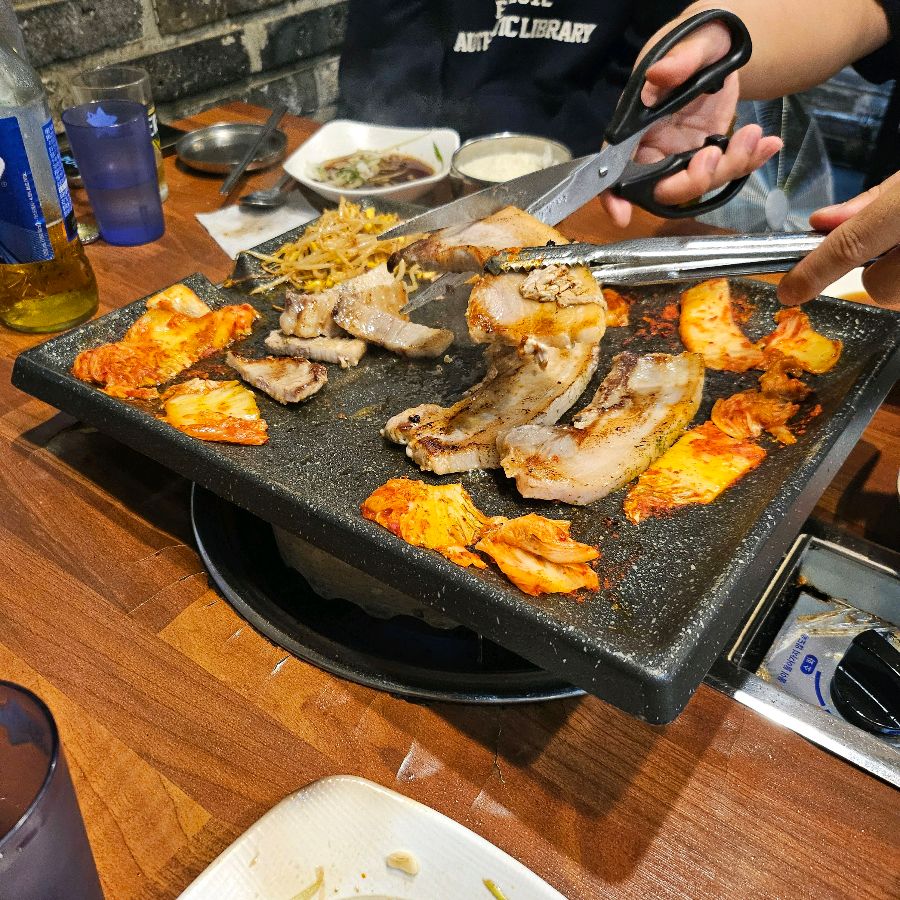 불판 위에서 익어가는 삼겹살과 김치