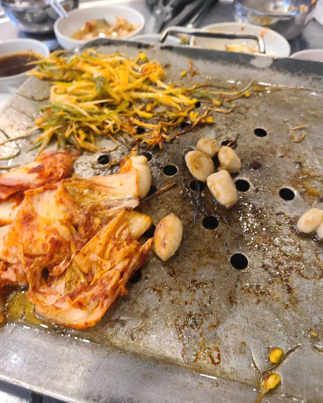 불판 위에서 익어가는 김치와 마늘