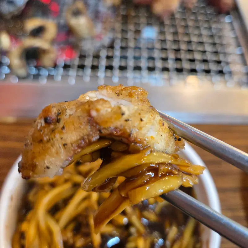 젓가락으로 집어 올린 장어 한 점