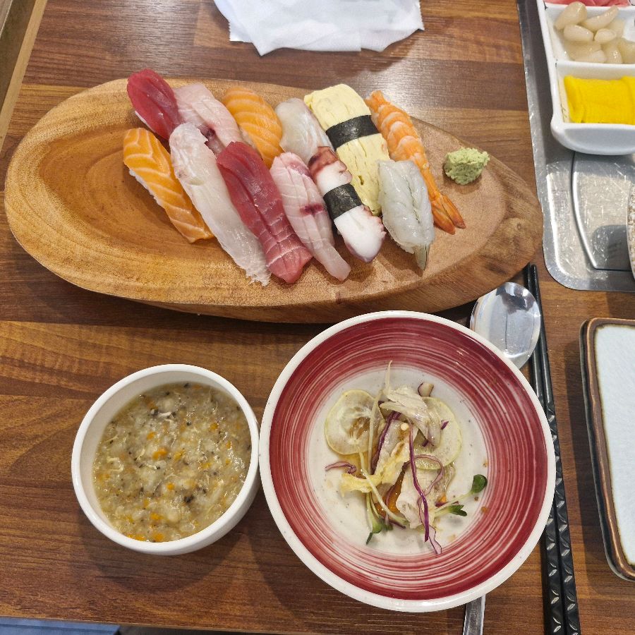 샐러드, 죽, 초밥이 함께 놓인 테이블 전경